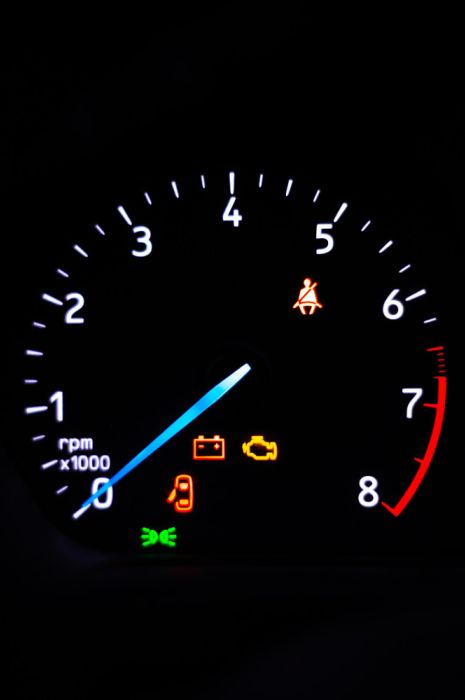 car dashboard with speedometer and alert lights for engine faults