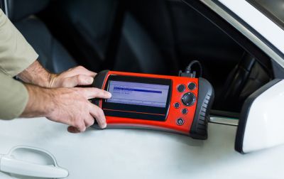 Hands of mechanic using a diagnostic tool
